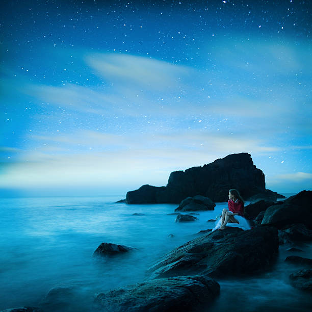 Girl Sitting on black rocks
