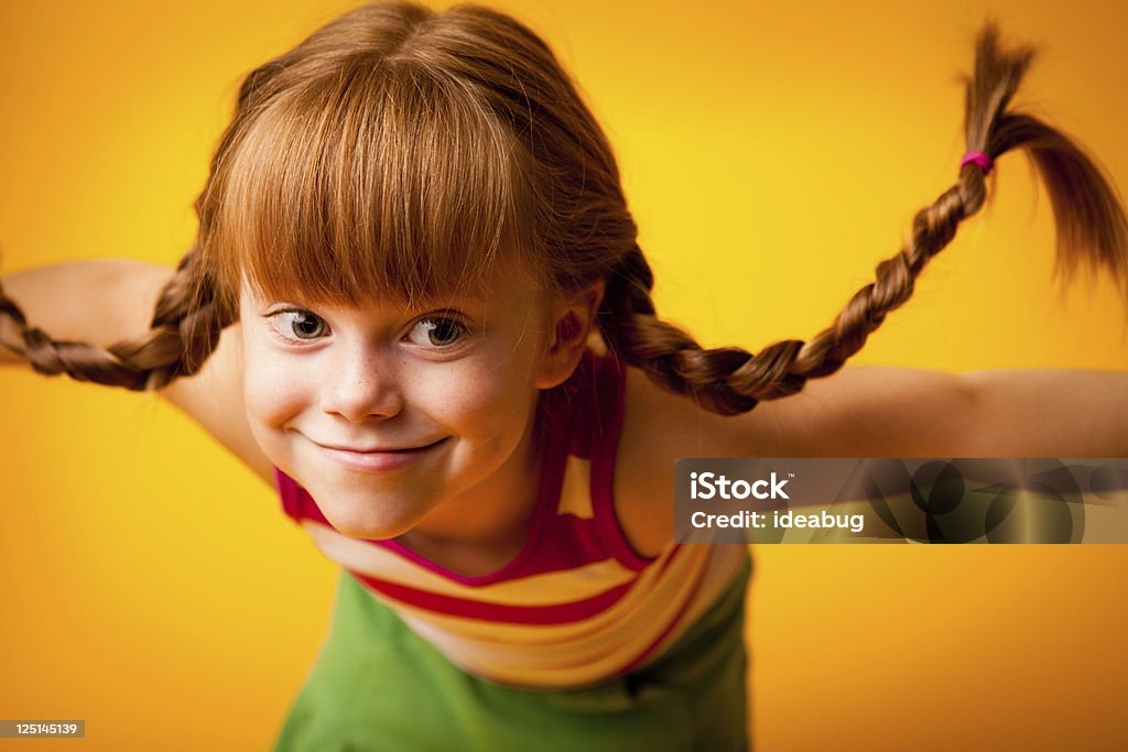 Red de Pêlo menina com tranças para cima e o Pateta sorriso - Foto de stock de Menina royalty-free