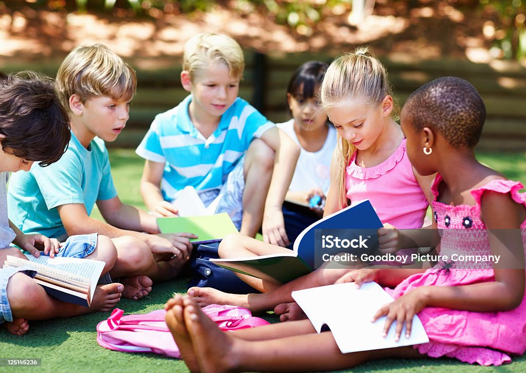 Crianças sentado na grama e estudar - Royalty-free Aluno da Escola Primária Foto de stock