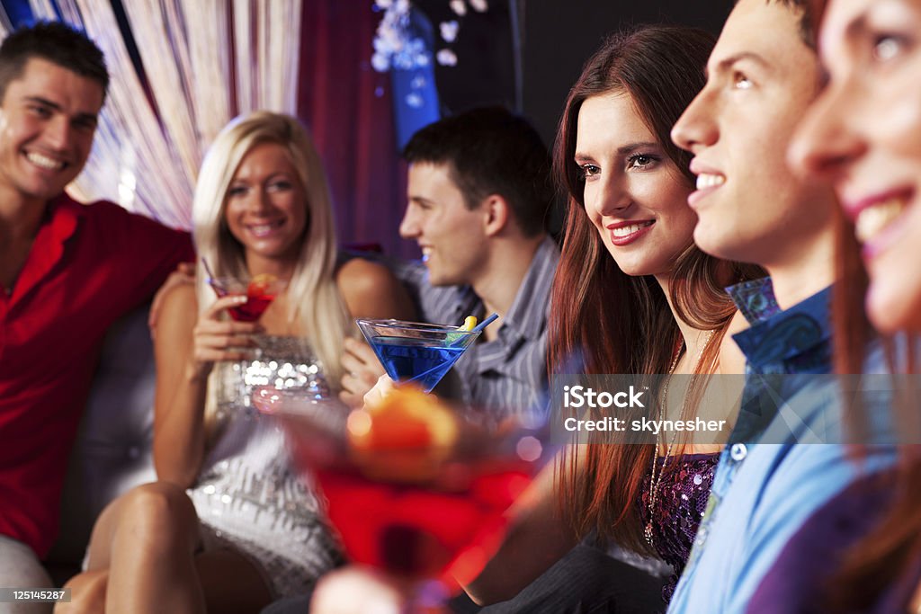 Grupo de pessoas sentado à discoteca club e beber - Foto de stock de Encontro Social royalty-free