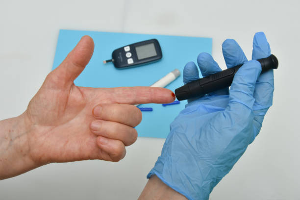 istock Doctor checking diabetic patient's blood sugar level with digital glucometer, closeup 1251453268