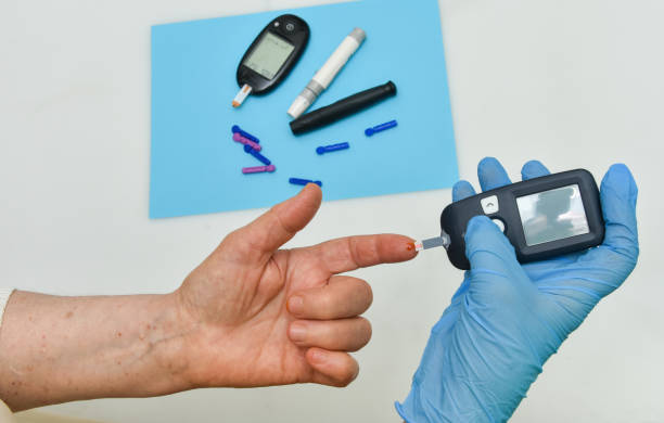 istock Doctor checking diabetic patient's blood sugar level with digital glucometer, closeup 1251453276