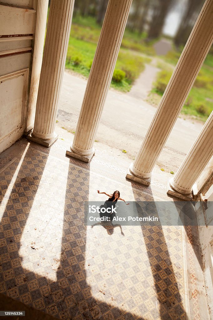 Une femme danse dans un ancien palais au sol - Photo de Danser libre de droits