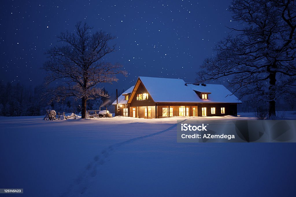 Home at christmas Illuminated house in wintery scene with footpath to it. House Stock Photo