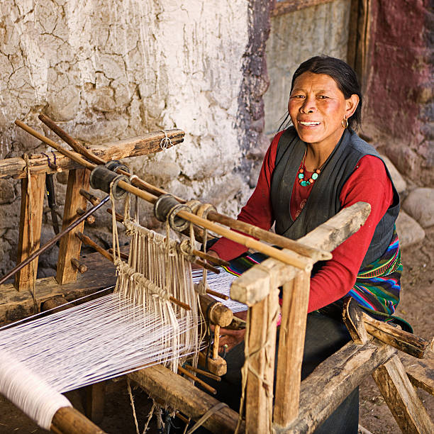 istock Tibetan woman weaving a carpet 125145529
