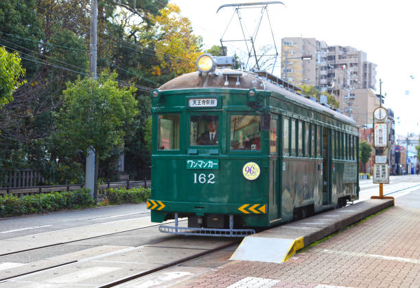 Osaka, Japan - December 14, 2018. A green tram in the city of Osaka in Japan.