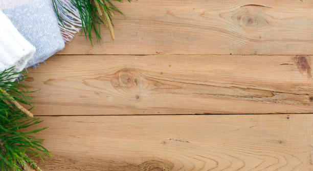 istock Christmas flatlay on a rustic wooden background: green pine needles with cones, warm woolen things in white and blue. 1251457008
