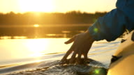istock man puts fingers down lake kayaking against backdrop of golden sunset, unity harmony nature 1251458087