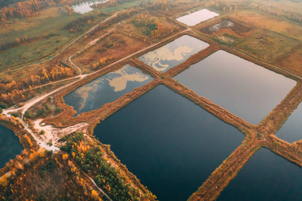 bassins de rétention, étang humide, bassin de détention humide ou étang de gestion des eaux pluviales, est un étang artificiel avec de la végétation autour du périmètre, et comprend un bassin permanent d’eau dans sa conception - retention pond photos et images de collection