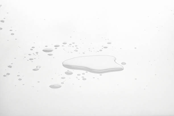 istock Water puddles and droplets on white reflective surface. Frontal view and deep focus. 1251463928