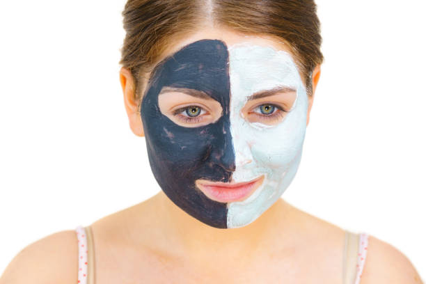 istock Girl with black white mud mask on face 1251465179
