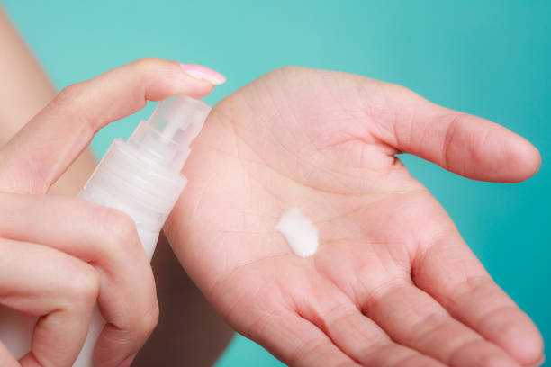 istock Woman putting white cream on hand 1251465228