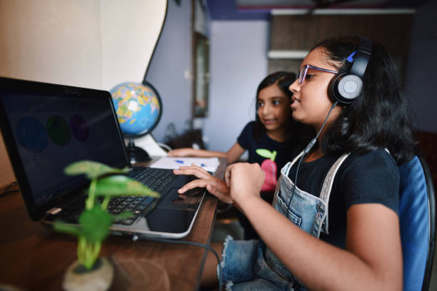 istock Elder sister attending online class while younger sister watches 1251472284