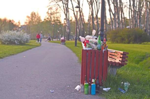 夕暮れ時の公共公園にあふれるゴミ箱。プラスチック汚染。 - garbage can garbage overflowing full ストックフォトと画像