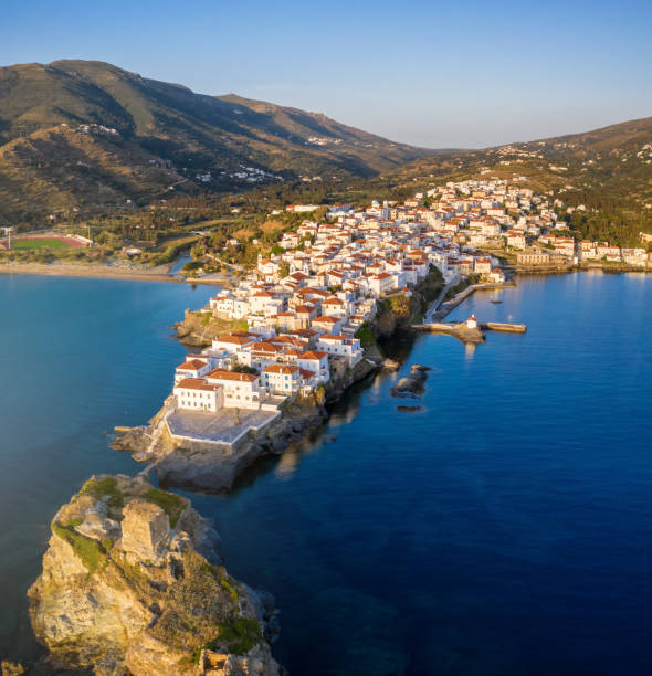 Aerial view of the beautiful town of Andros island during summer sunrise, Greece Aerial view of the beautiful town of Andros island during summer sunrise with soft color tones and calm sea, Cyclades, Greece andros island stock pictures, royalty-free photos & images