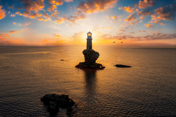 istock A lighthouse on a steep rock within the mediterranean sea during sunrise 1251474196