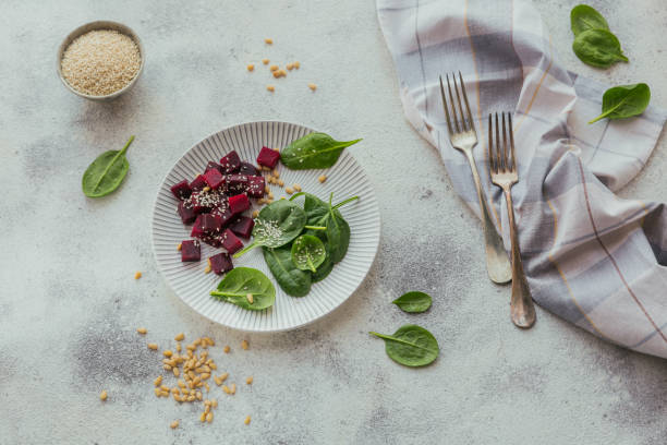istock Healthy breakfast with boiled beetroot, spinach leaves, pine nuts and sesame seeds on white background 1251475496