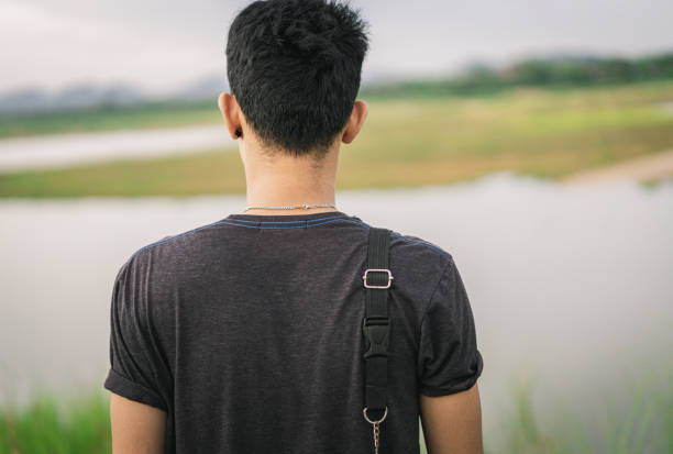 istock Young Asian man standing on his back looking at the view 1251479238