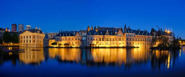 Panorama of the Binnenhof House of Parliament and Mauritshuis museum and the Hofvijver lake illuminated in the night. The Hague, Netherlands