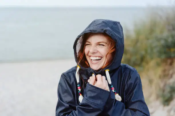 Photo of Laughing happy woman embracing the cold weather