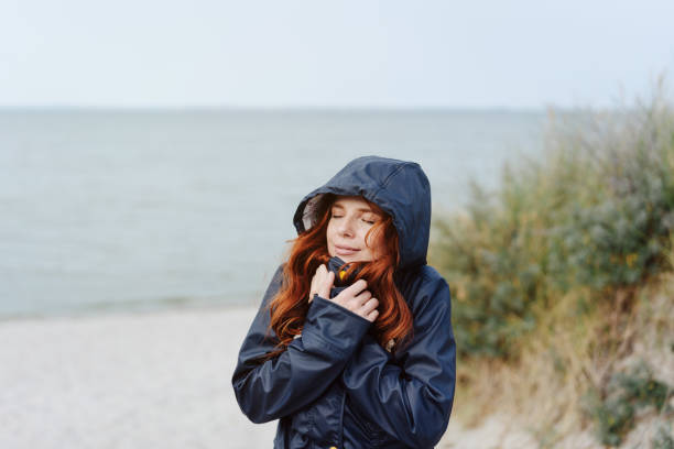istock Young woman snuggling into a warm anorak 1251480611