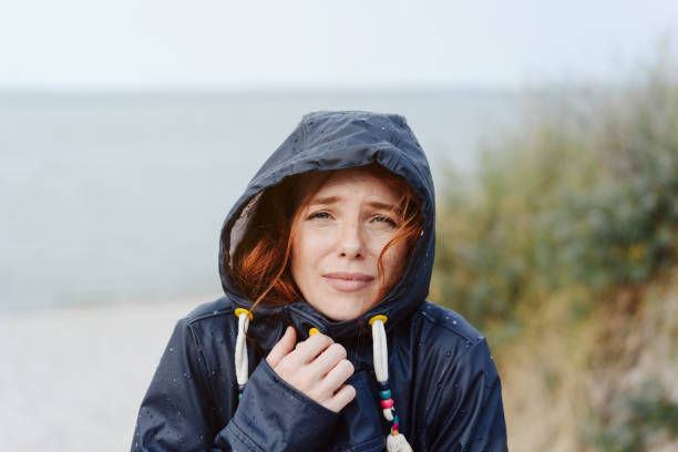 istock Freezing cold woman snuggling into her anorak 1251481036