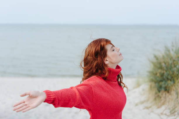 istock Serene young woman meditating on a beach 1251481831