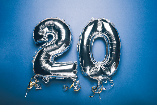 Silver Number Balloon 20 on blue background. Holiday Party Decoration or postcard concept with top view on blue background