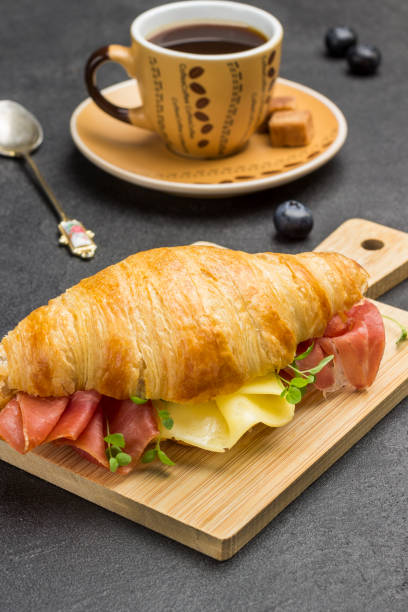 istock Croissant with jamon and cheese and greens. 1251483411