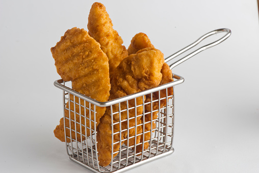 Crispy chicken nuggets with a tomato ketchup sachet - white background