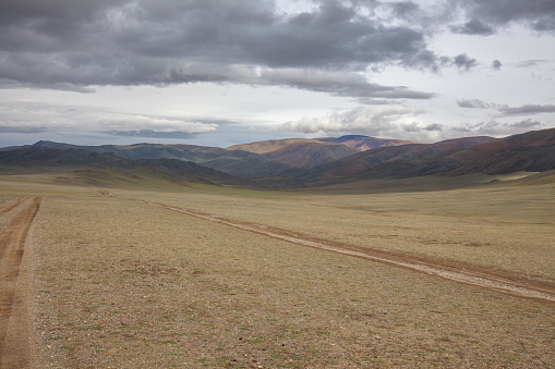 The lonely highway in the huge steppe, Ovorkhangai aimag, Mongolia. This highway is one of many silent highways in the steppes as well as in the deserts in the country. Mongolia is indeed the land of nomads.