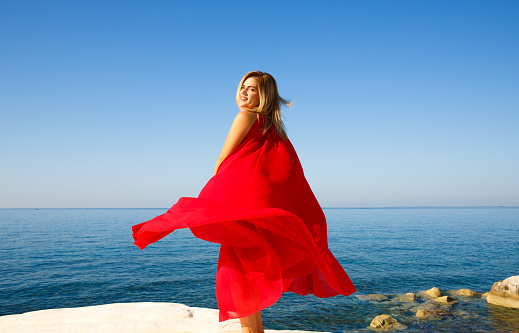 Woman in the red dress at the beach in Cyprus.