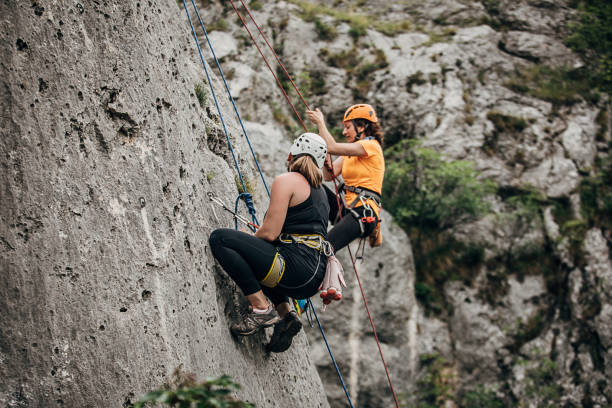 istock Two women free climbers climbing high 1251488419