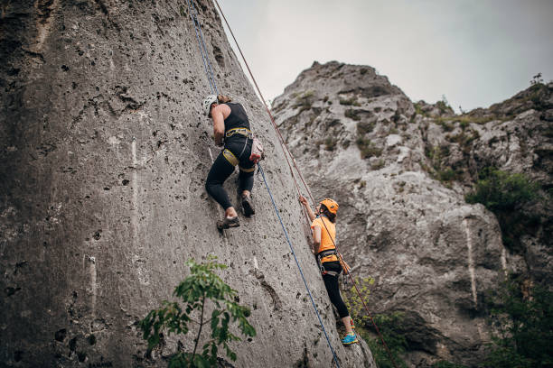 istock Two strong women free climbers climbing high 1251488494