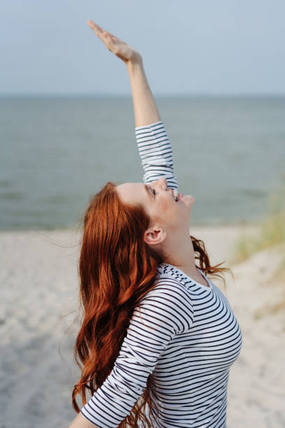 istock Beautiful red-haired girl stretching her arms 1251489877