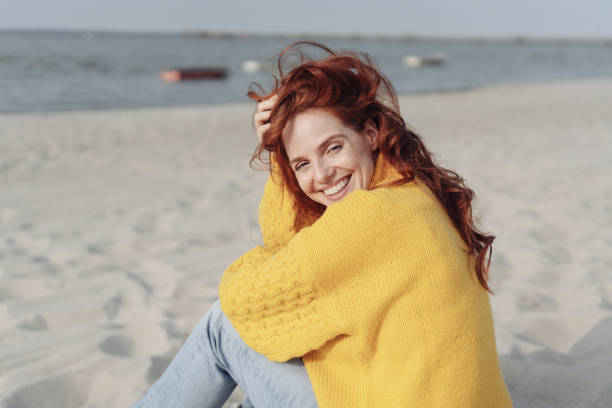 istock Pretty friendly redhead woman on a beach 1251490008