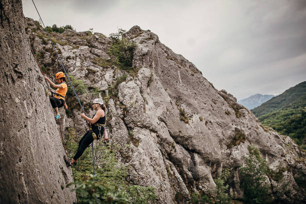istock Female free climbers climbing on the rock mountain 1251490816