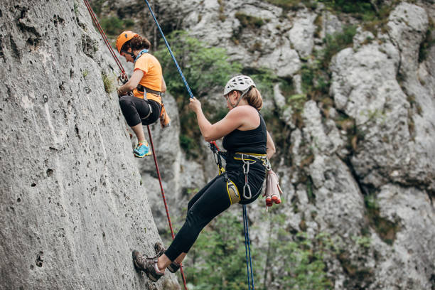 istock Female free climbers climbing on the rock 1251490846