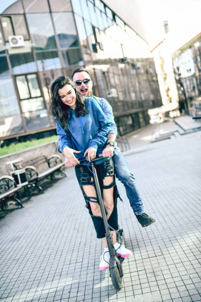 istock Smiling Couple Having Fun With Electric Scooter 1251492283