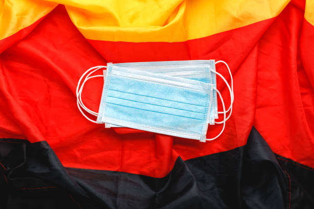 istock Coronavirus in Germany. Protective surgical face mask on Deutsch national flag. Germany quarantine,protection coronavirus symbol of doctor, nurse, medical worker. Medicine health care. Covid-19 1251492607