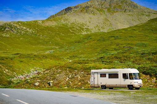 Tourism vacation and travel. Camper car in green summer mountains landscape. National tourist route Aurlandsfjellet.