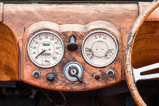 wooden steering wheel and dashboard interior of a vintage automobile