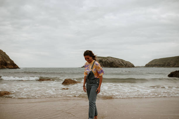 istock Young woman walking and having fun at the beach 1251497787