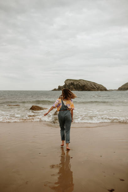 istock Young woman walking and having fun at the beach 1251497858