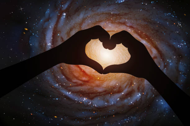 istock Spiral galaxy in heart shaped hands of astronaut in space 1251500918