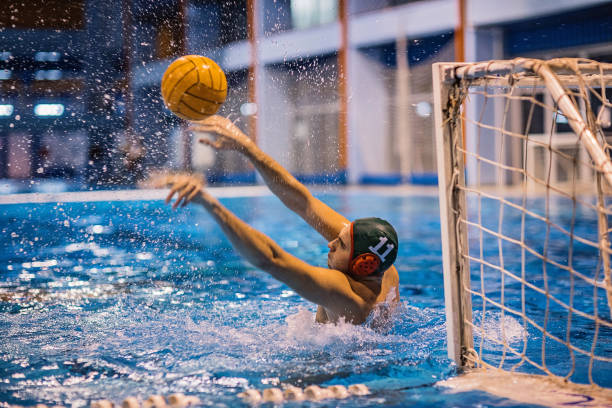 Water polo goalkeeper failed to defend the goal in water polo match One young man, water polo goalkeeper, failed to defend the goal in water polo match indoors. water polo stock pictures, royalty-free photos & images