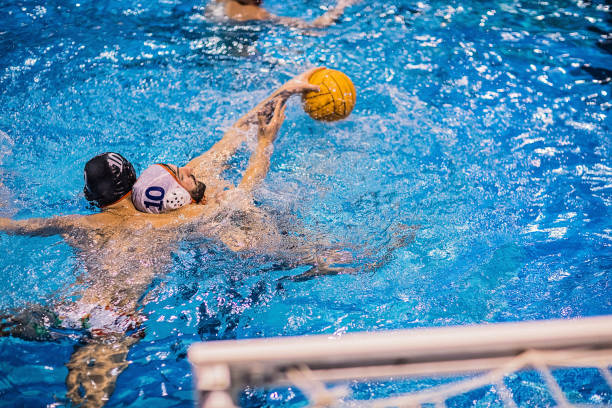 istock Two young men playing a water polo match 1251502373