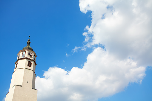 belfry with christian cross and clouds on blue sky