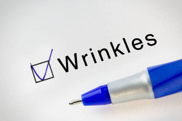 istock Wrinkles text on test paper with check mark in form box. Diseases names test series. 1251511601