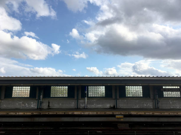Empty elevated subway platform in New York City. Vacant overground subway station on a bright day with blue skies. Empty train station in NYC room for copy.